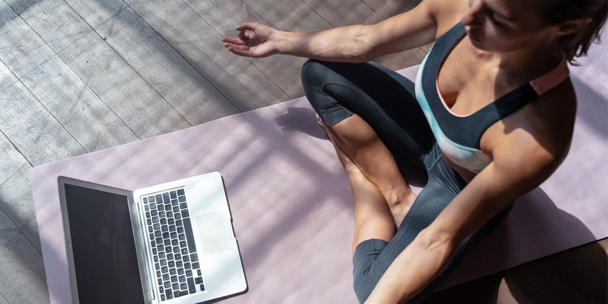 Woman with laptop while in a yoga pose.